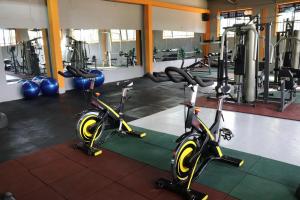 a gym with two exercise bikes and weights at Biyem Hotel in Kampala