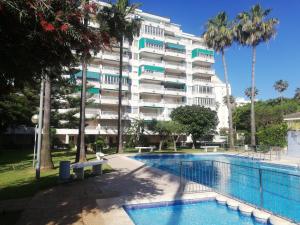 a hotel with a swimming pool in front of a building at Parque IV Solo Familias Serviplaya in Gandía