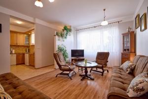 salon z kanapą i stołem w obiekcie Apartament Zuzia w Dźwirzynie +16 zdjęć