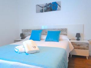 a bedroom with a blue and white bed with blue pillows at Almagro a un paso in Almagro