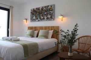 una camera da letto con un letto con lenzuola bianche e una sedia di Hotel Fazio a Bonifacio