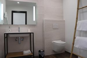 a bathroom with a sink and a toilet and a mirror at Hotel Fazio in Bonifacio +25 photos