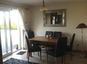a dining room table with chairs and a mirror at Eden House in Carlingford