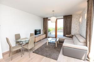 パランガにあるSea View Penthouse Terrace Palanga Old Townのソファとテーブルのあるリビングルーム