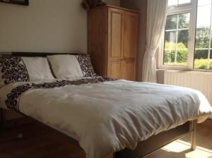 ein Bett in einem Schlafzimmer mit einem Fenster in der Unterkunft Eden House in Carlingford