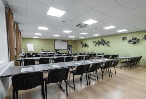 a conference room with tables and chairs and a screen at BNC Hotel - Restaurant - Bowling in Bratislava