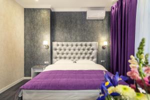a bedroom with a large bed with a purple blanket at Apartments in City Center Area in Kyiv