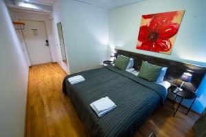 1 dormitorio con 1 cama y una pintura en la pared en Hotell Kvarntorget en Uppsala