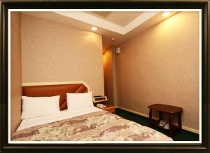 1 dormitorio con 1 cama y 1 mesa en Ye-Shi Ri-Xin 日新旅社022, en Luodong