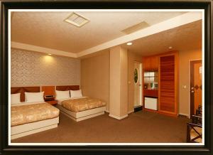 a hotel room with two beds and a hallway at Ye-Shi Ri-Xin 日新旅社022 in Luodong