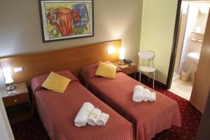 two beds in a hotel room with shoes on them at Hotel Lugano in Milan +29 photos
