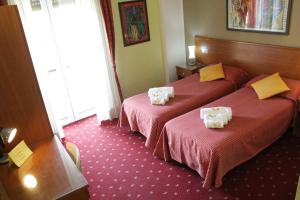 two beds in a hotel room with towels on them at Hotel Lugano in Milan