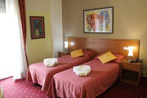 a hotel room with two beds with red sheets at Hotel Lugano in Milan