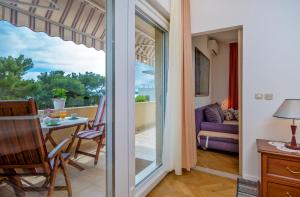 a room with a balcony with a table and a couch at Apartments Emi in Split