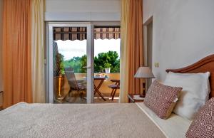 a bedroom with a bed and a balcony with a table at Apartments Emi in Split