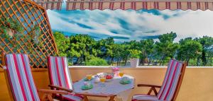 a table and two chairs with a table and a window at Apartments Emi in Split