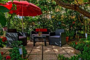 a group of chairs and an umbrella on a patio at Apartments Emi in Split