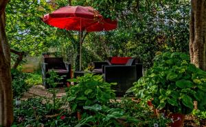 a red umbrella and some chairs and a table at Apartments Emi in Split