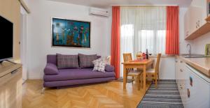a living room with a purple couch and a table at Apartments Emi in Split