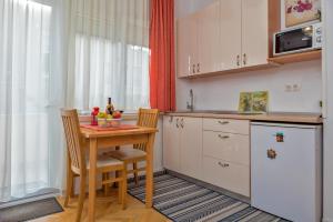 a small kitchen with a table and a refrigerator at Apartments Emi in Split