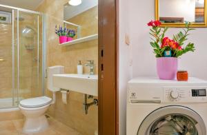 a bathroom with a washing machine and a washer at Apartments Emi in Split