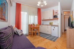 a living room with a couch and a table and a kitchen at Apartments Emi in Split +29 photos