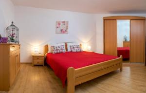 a bedroom with a large red bed with two pillows at Apartments Emi in Split