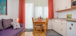 a living room with a table and a kitchen at Apartments Emi in Split