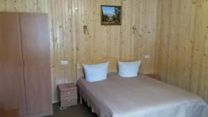 a bedroom with a bed with two white pillows at raduga karpat in Yaremche