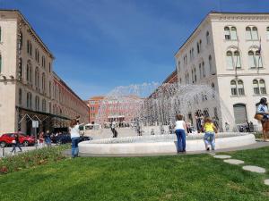 a group of people standing around a fountain in a city at Apartments Emi in Split