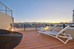 een balkon met een stoel en een tafel op een gebouw bij Spinola Court - Stunning Seaview Apartment & Penthouse on Spinola Bay by ShortletsMalta in St Julian's