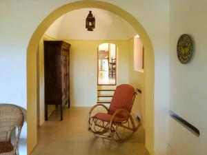 un couloir voûté avec deux chaises et une horloge dans l'établissement Relais Euterpini, à Pantelleria