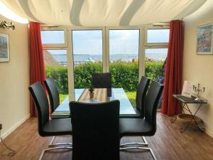 ein Esszimmer mit einem Tisch, Stühlen und einem Fenster in der Unterkunft Ferienhaus Südblick am Yachthafen in Breege