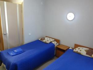 - 2 lits dans une chambre avec des draps bleus dans l'établissement Hotel Lotos, à Irkoutsk