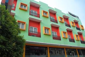 a multicolored building with orange and green at RedDoorz At Hotel Gajah Mada Palu in Palu