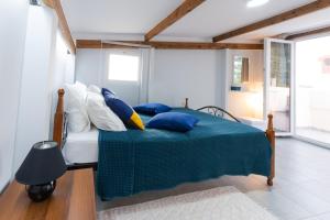 Schlafzimmer mit einem Bett mit blauen und weißen Kissen in der Unterkunft Blue Heaven in Hersonissos