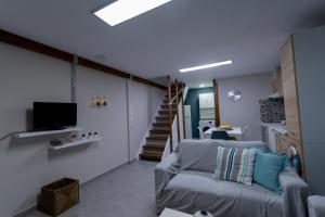 een woonkamer met een bank en een tv bij Blue Heaven in Chersonissos