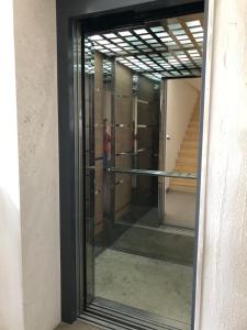 Ein Spiegelbild eines Mannes in einem Flur mit Glastüren. in der Unterkunft Center Apartment in Vlorë