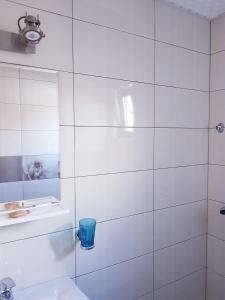 スリナにあるPensiunea Casa Blancaの白いタイル張りのバスルーム(トイレ、シンク付)