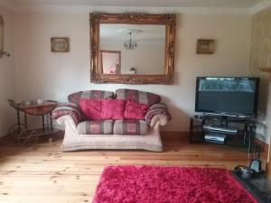 a living room with a couch and a tv at Eden House in Carlingford