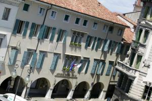un gran edificio con persianas azules en una calle en Astoria Hotel Italia, en Udine