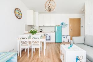 kuchnia i salon ze stołem i lodówką w obiekcie Imperial Apartments - Sopocka Przystań w mieście Sopot