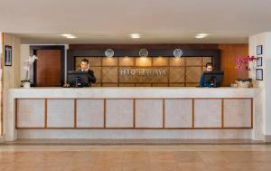 two men sitting at a reception desk in a hotel lobby at H10 Tindaya in Costa Calma