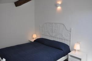 een slaapkamer met een blauw bed en 2 lampen bij Villa Lucia home holiday in Carrodano Inferiore