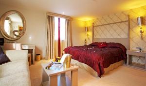 a bedroom with a bed and a living room at The Pinewood Hotel in Slough