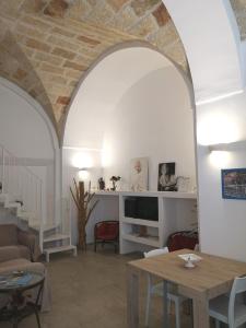 een woonkamer met een boog en een tafel bij Dimora Del Mar in Polignano a Mare