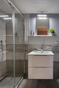 La salle de bains est pourvue d'un lavabo blanc et d'une douche. dans l'établissement San Giorgio 2, à Bologne