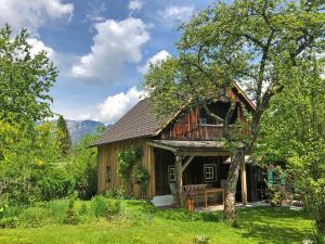ein großes Holzhaus mit einer Bank davor in der Unterkunft Chalet Ramsau 8 in Bad Goisern