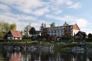 een gebouw naast een waterlichaam bij Pension Calla in Dolní Vltavice