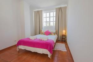 ヴィラ・ノヴァ・デ・ミルフォンテスにあるSUNNY HOUSE by Stay in Alentejoのベッドルーム1室(ピンクの毛布と窓付)